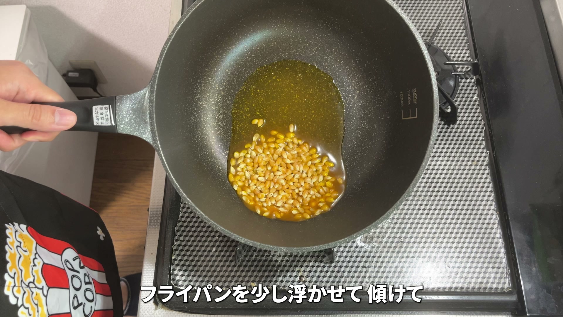フライパンを傾けて油だまりを作る様子